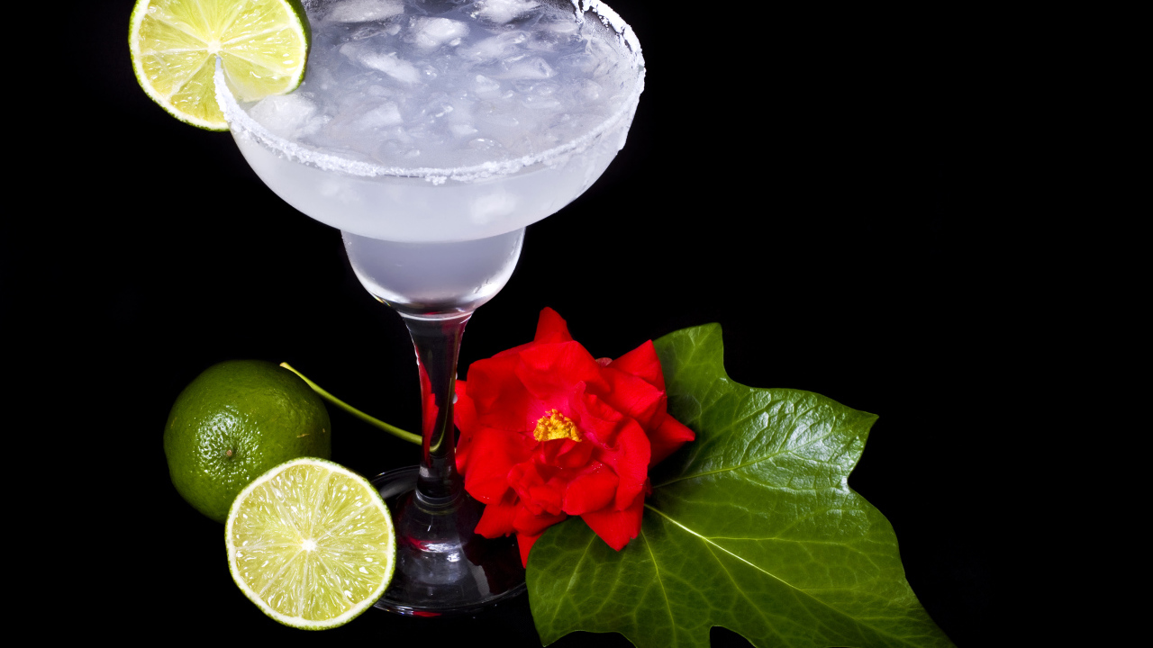 Бокал коктейля со льдом и лаймом на черном фоне