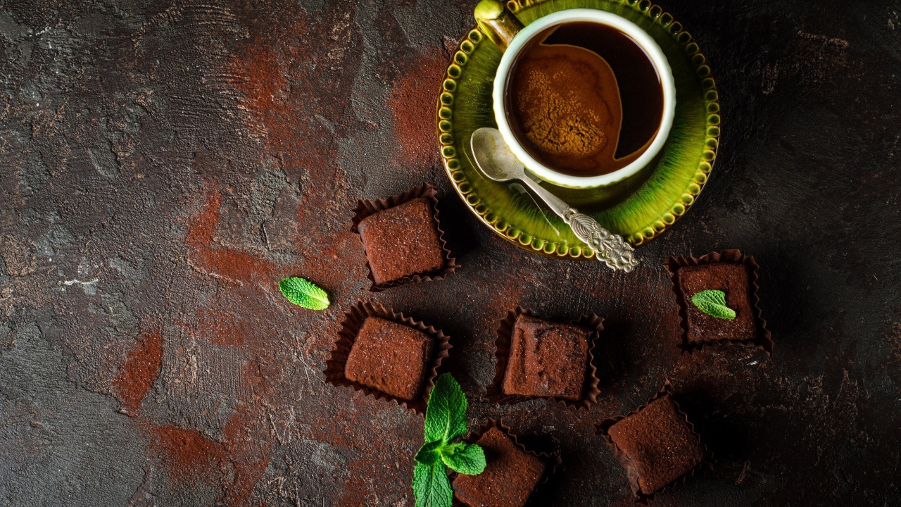 Ароматный кофе в чашке с шоколадными конфетами 