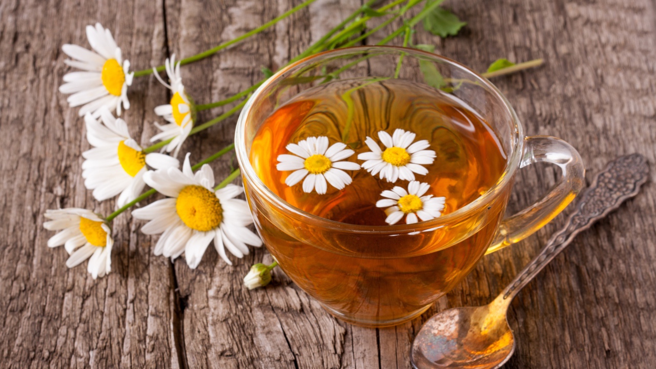 Стеклянная чашка чая с ромашкой