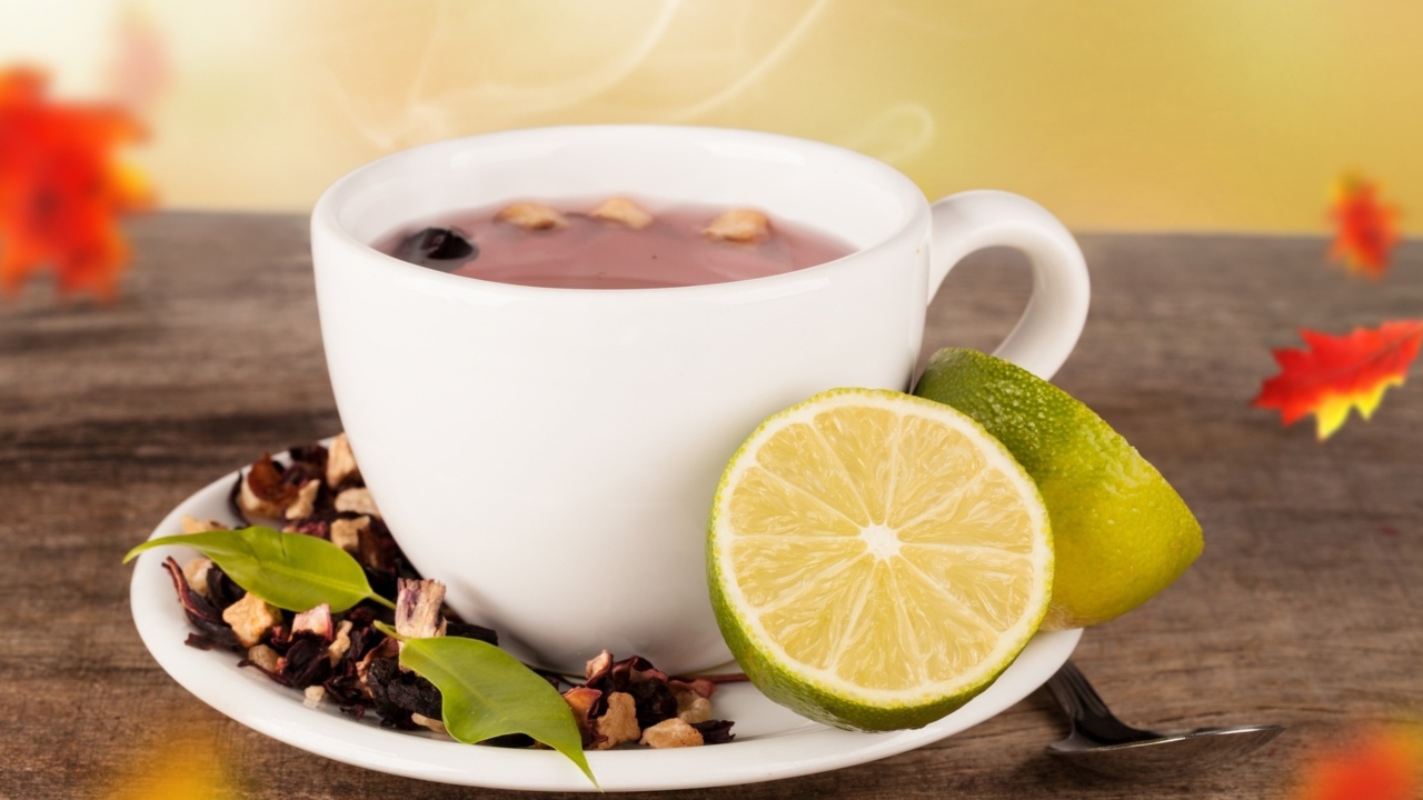 Белая чашка чая с кусочками лайма на белом блюдце