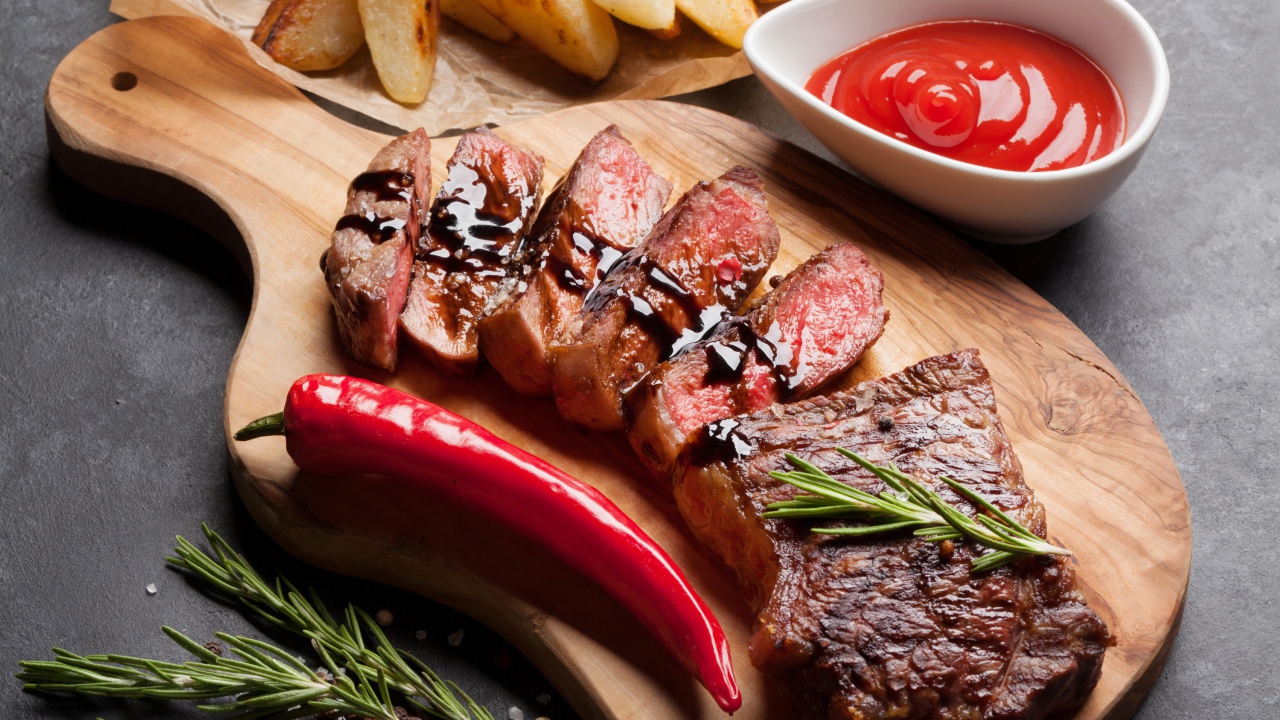 Аппетитный сочный стейк с соусом, красным перцем и специями на столе