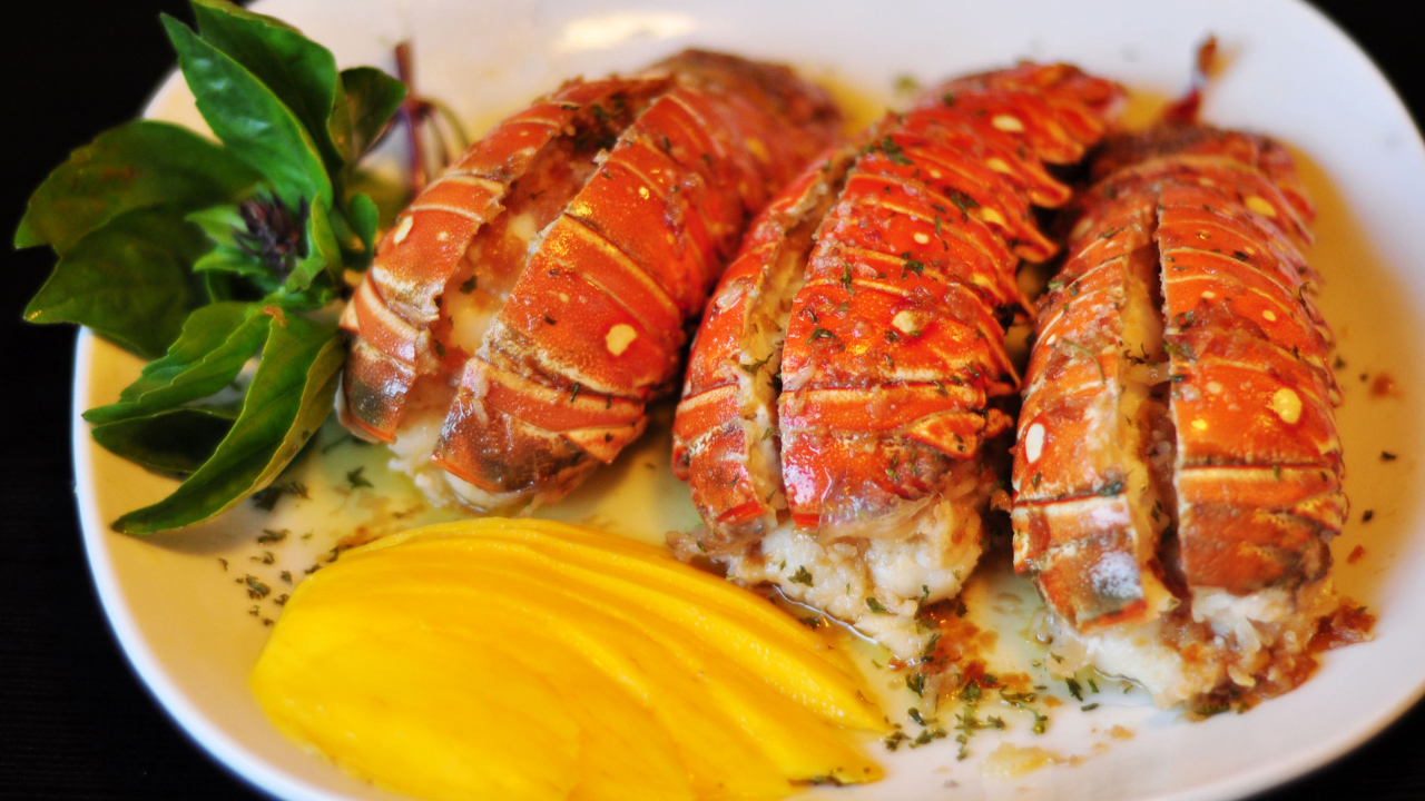 Омар с овощами на белой тарелке 