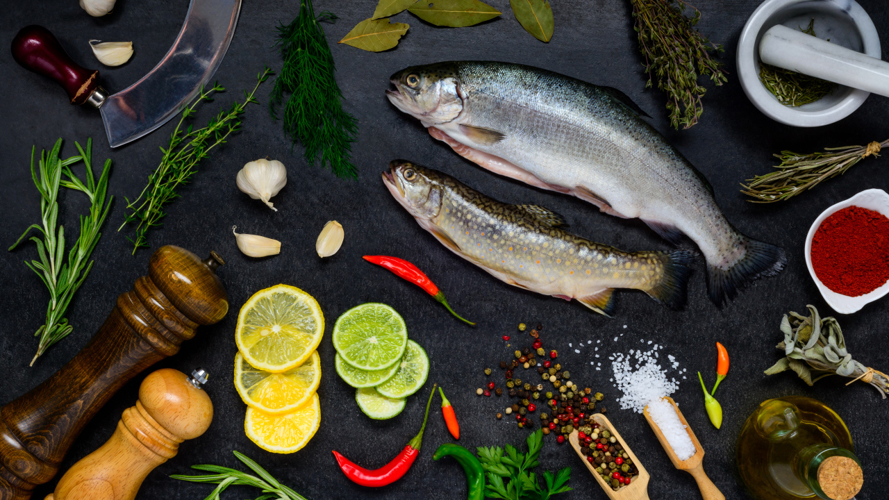 Сырая рыба на столе со специями и лимонами