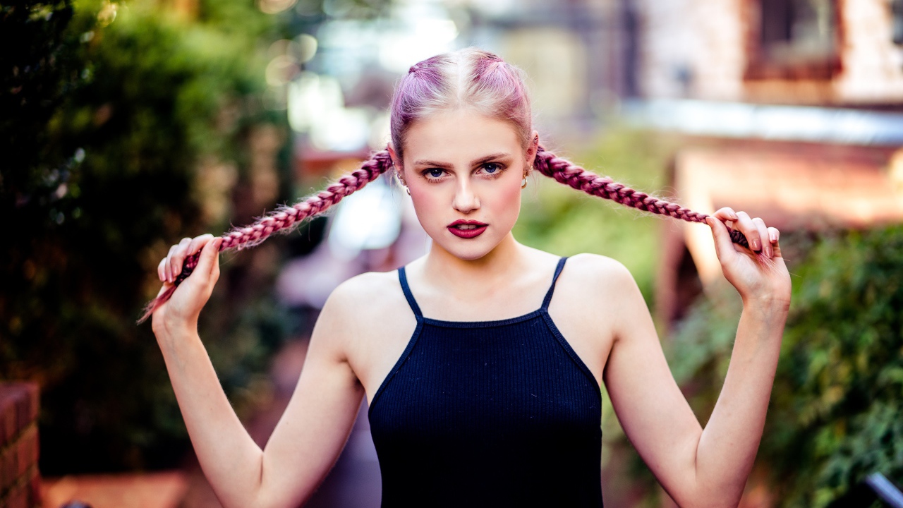 Молодая девушка с розовыми косами на голове