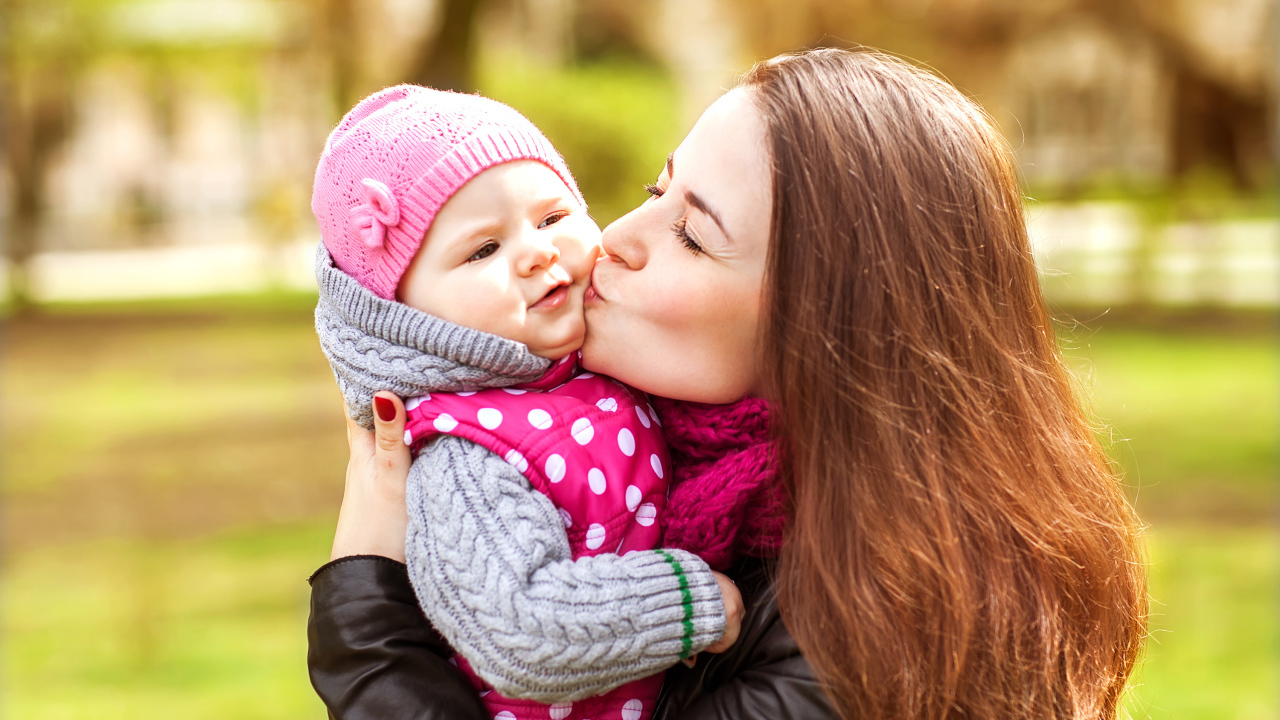 Красивая девушка держит в руках маленького ребенка