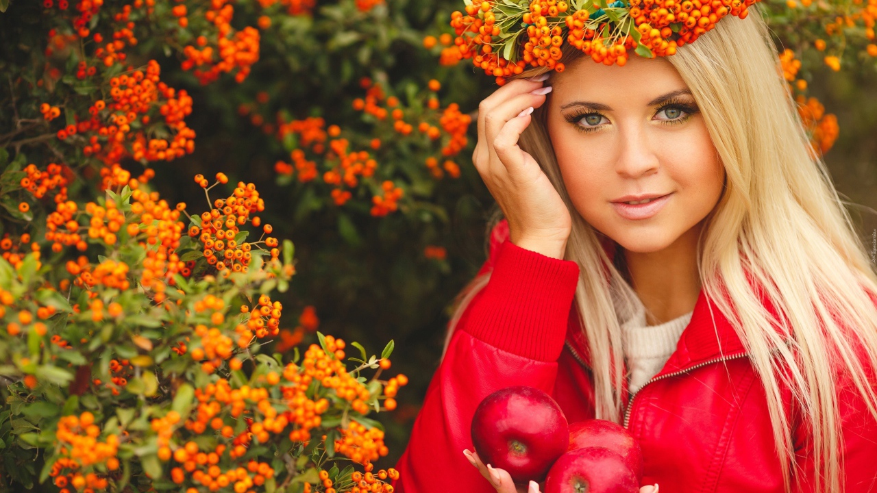 Красивая девушка с венком из рябины на голове и с красными яблоками в руках 