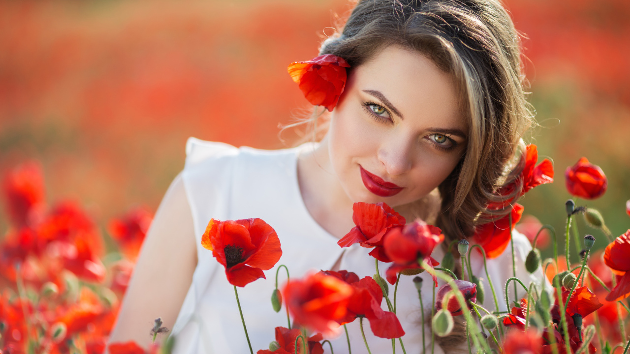 Красивая девушка с выразительным взглядом на поле с красными маками