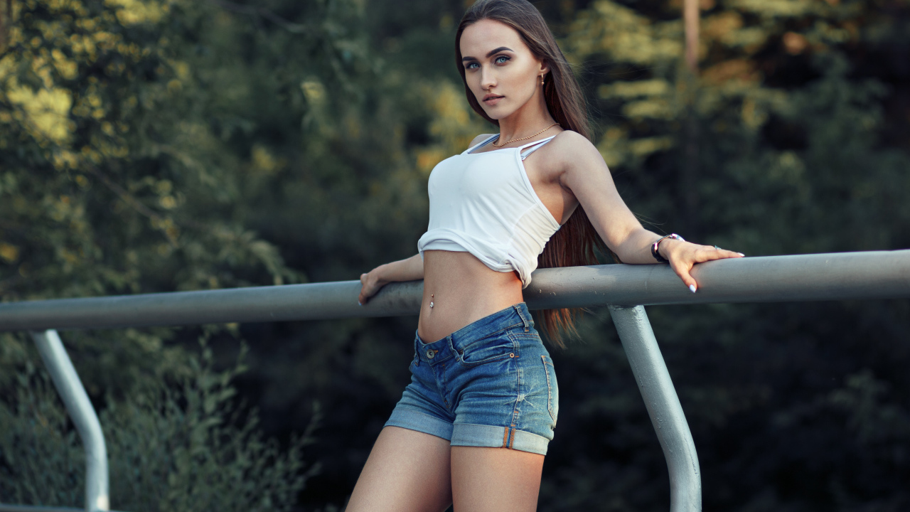 Красивая стройная девушка в джинсовых шортах