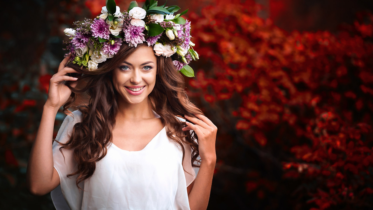 Красивая улыбающаяся девушка с венком из живых цветов на голове 