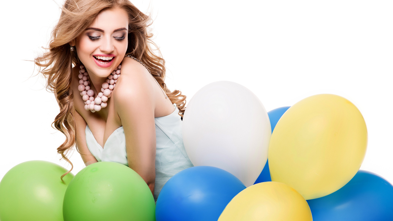 Красивая улыбающаяся девушка с разноцветными шариками на белом фоне