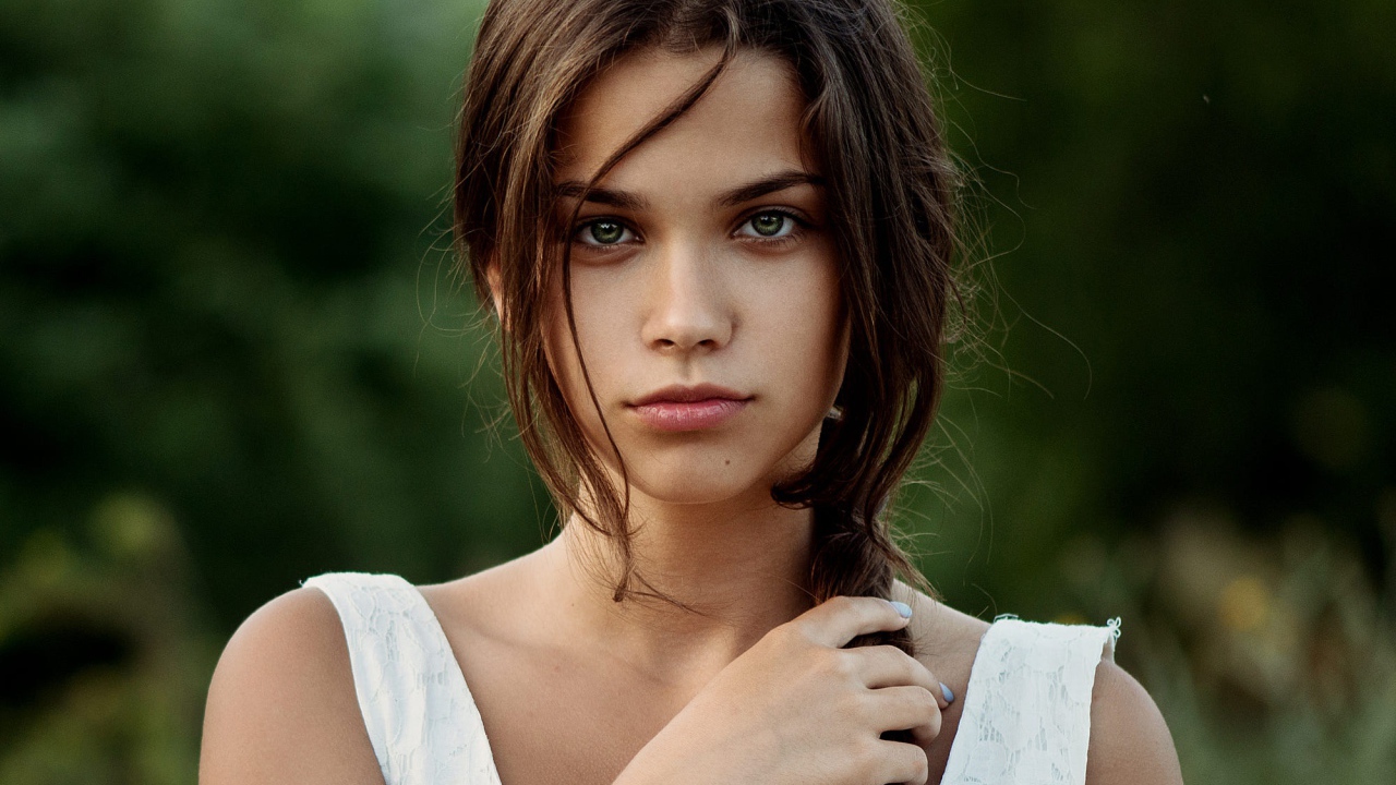 Красивая молодая зеленоглазая девушка с косой на голове