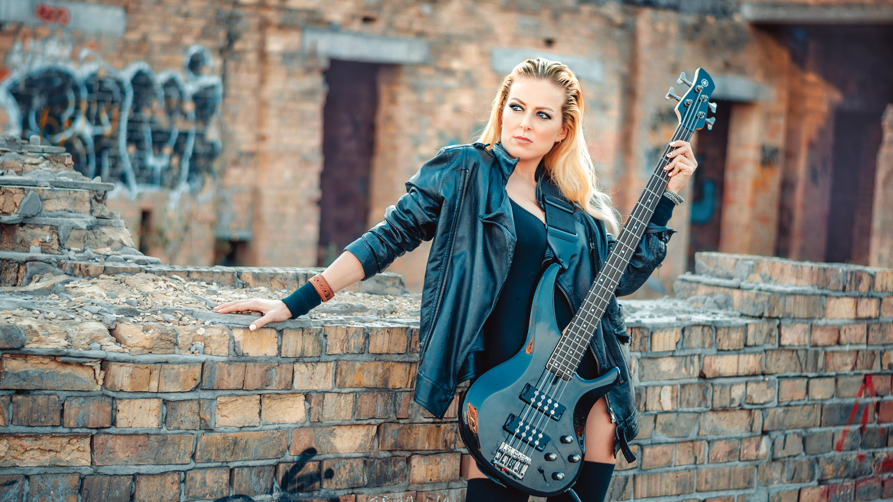 Блондинка в кожаной куртке с электрогитарой в руках