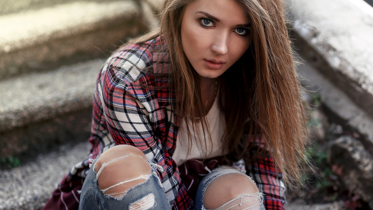 Голубоглазая девушка брюнетка в модных джинсах 