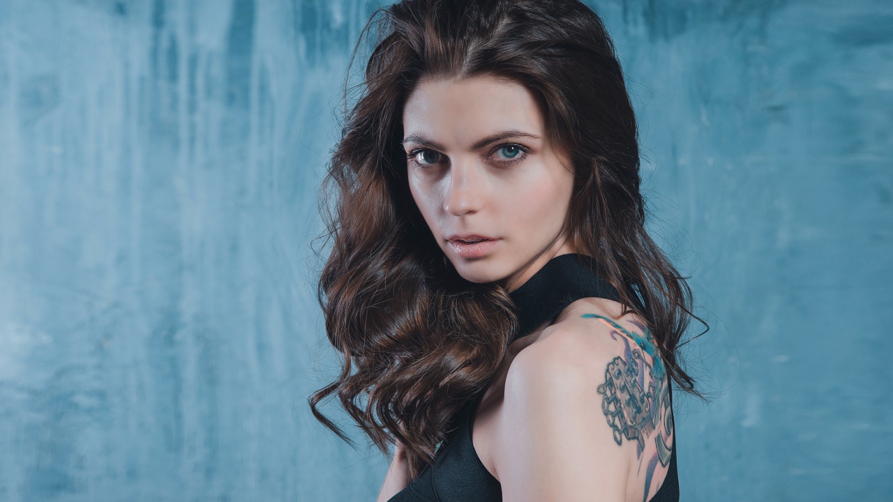 Голубоглазая девушка с татуировкой на спине 