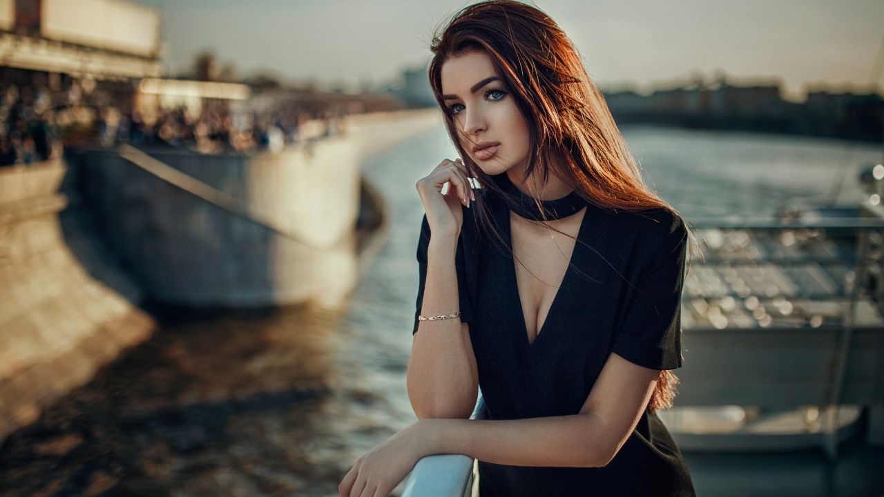 Голубоглазая девушка брюнетка в черном платье у воды 