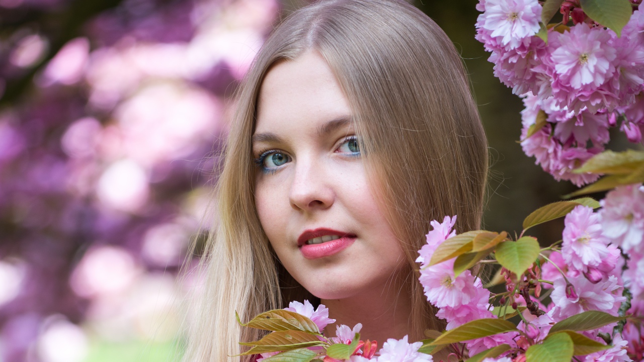 Милая голубоглазая девушка с розовыми цветами 