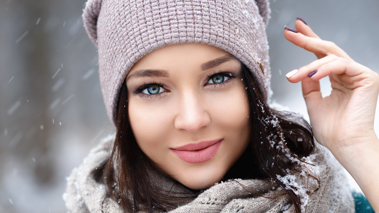 Милая голубоглазая брюнетка в теплой шапке зимой
