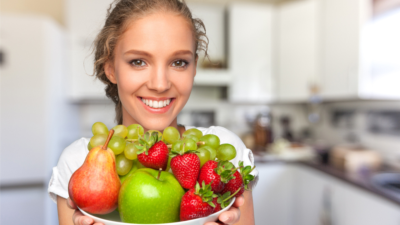 Улыбающаяся девушка со свежими фруктами 