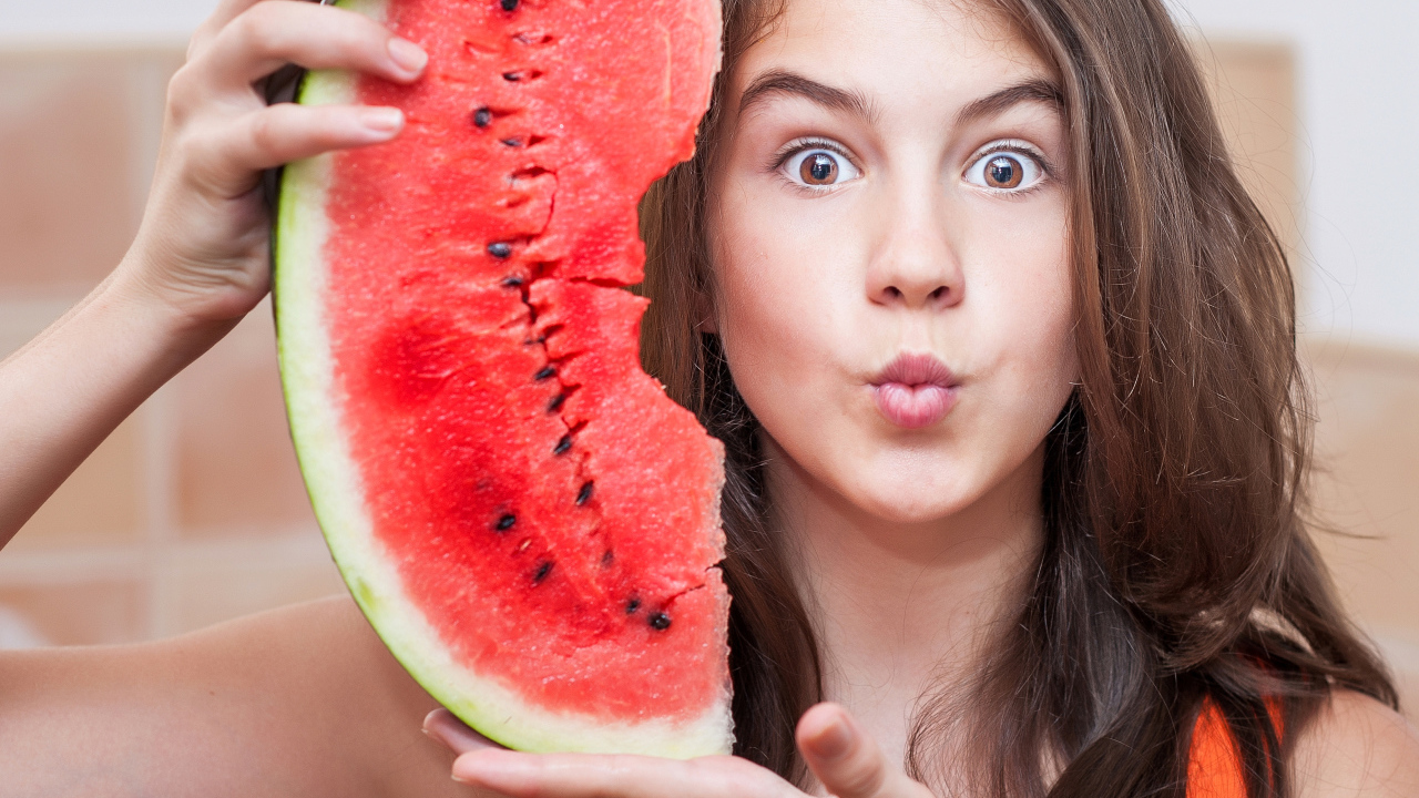 Девушка держит в руках скибку арбуза