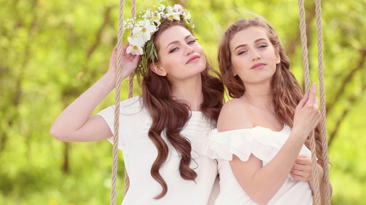 Две красивые длинноволосые девушки шатенки на качели