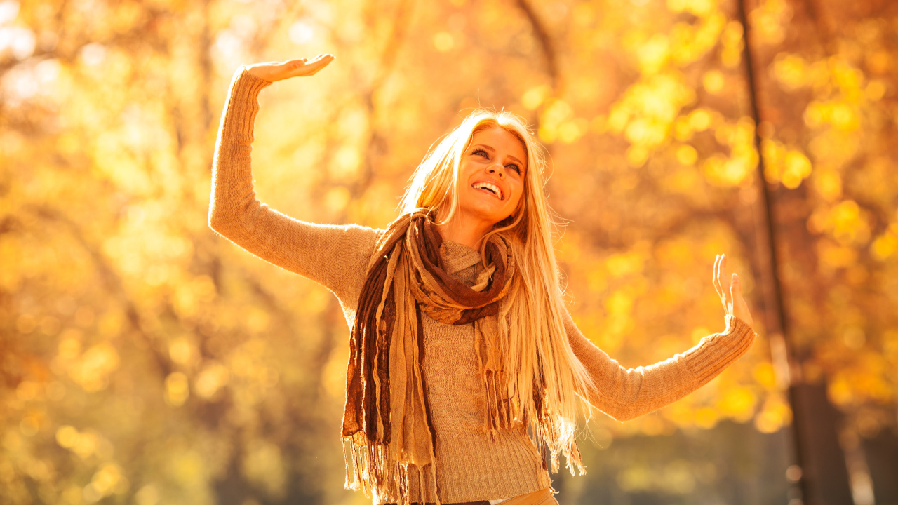 Молодая красивая девушка радуется теплому осеннему солнцу