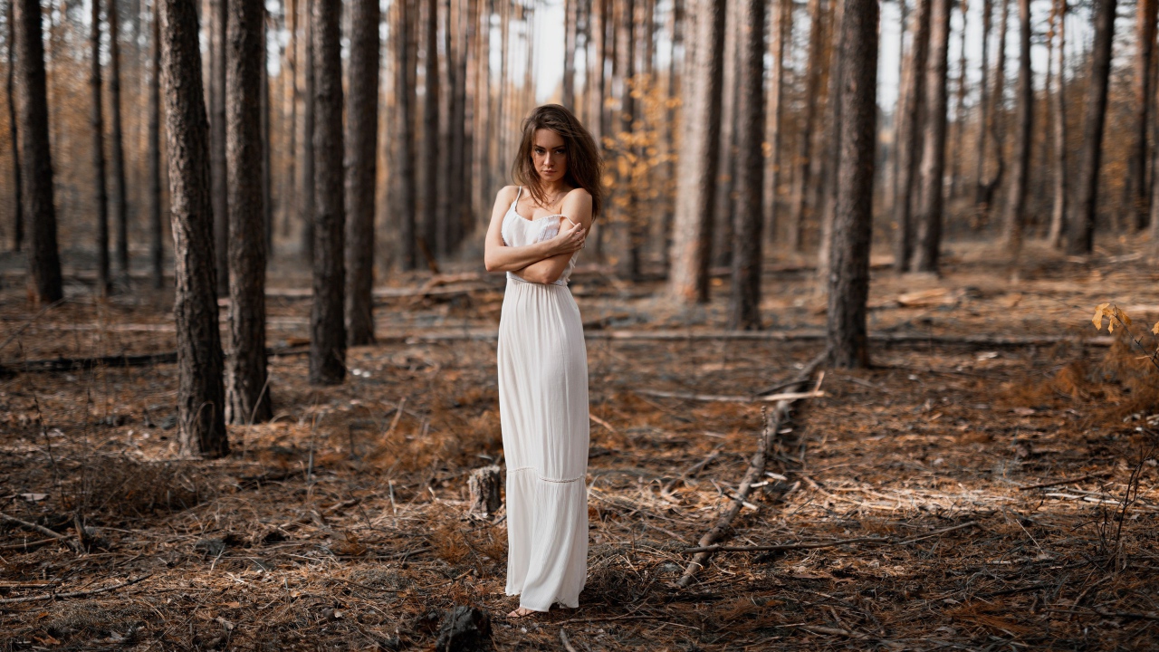 Молодая девушка в белом платье в лесу 