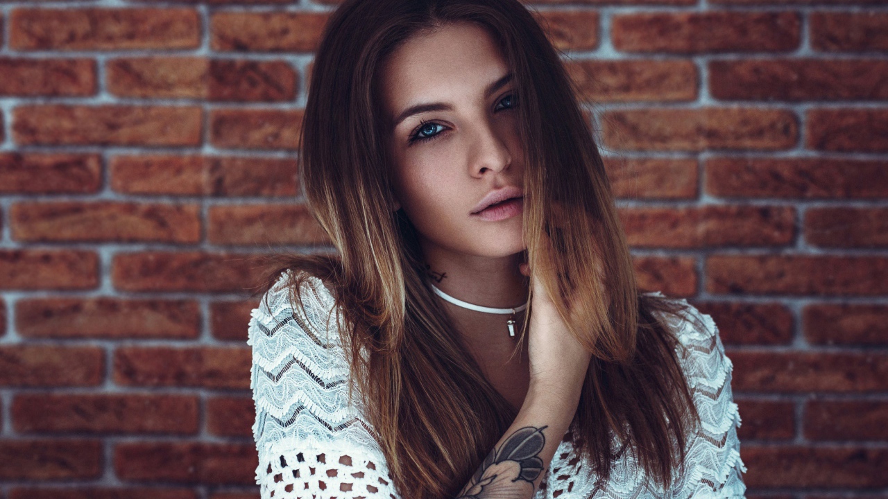 Молодая девушка с татуировкой на руке