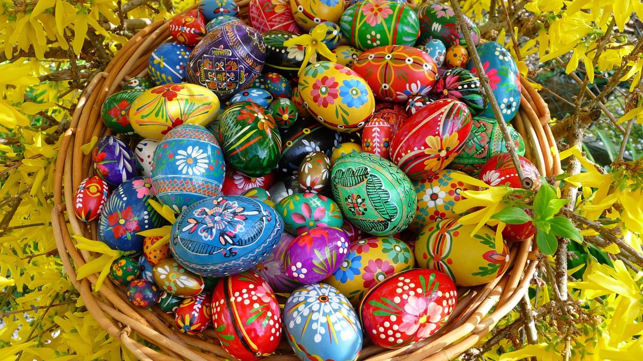 Яркие расписные пасхальные яйца в корзине 