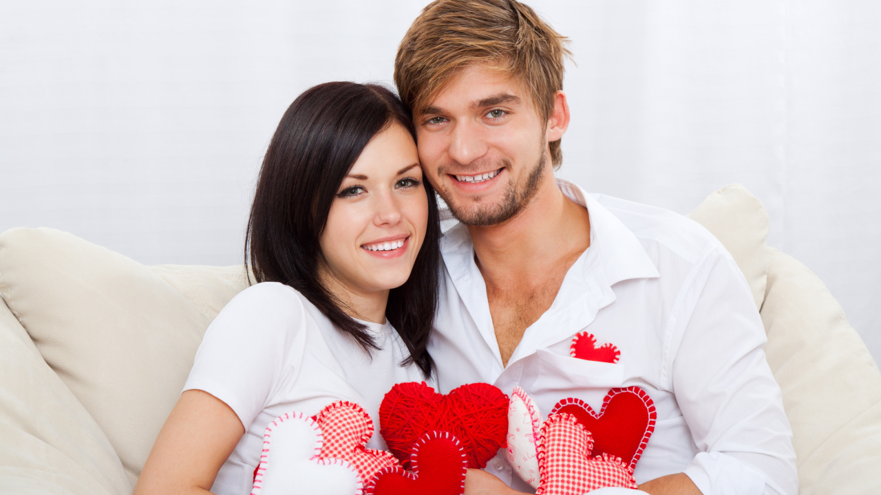 Красивая влюбленная пара с маленькими сердечками в руках