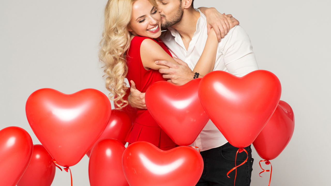 Счастливая влюбленная пара с воздушными шариками в форме сердца