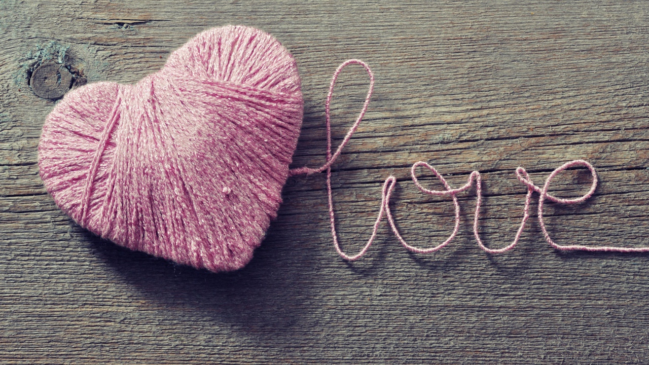 Надпись Love из розовых ниток на деревянном столе