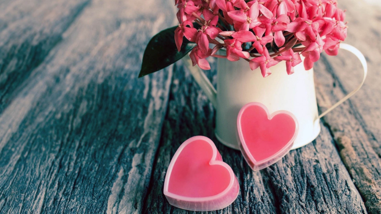 Розовые цветы в белой вазе и два розовых сердца 