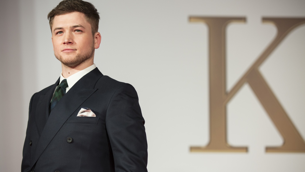 Молодой актер Терон Эгертон в черном пиджаке