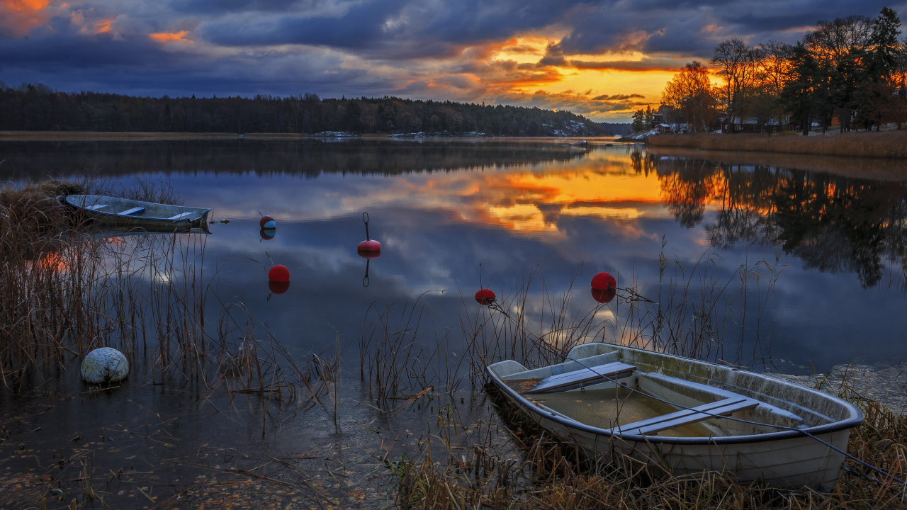 Лодки в тихом лесном озере на закате солнца