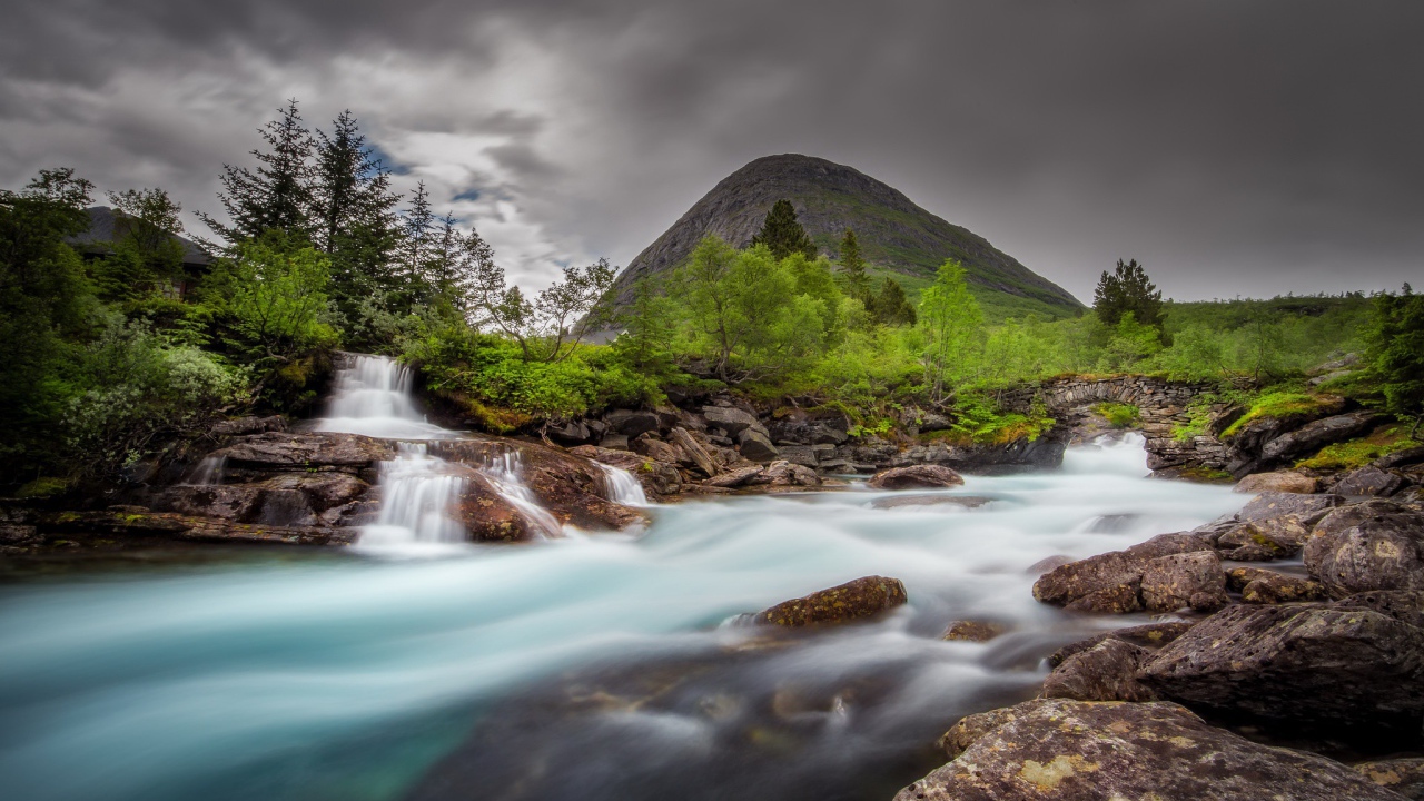 Быстрая вода в горной реке с маленьким водопадом 