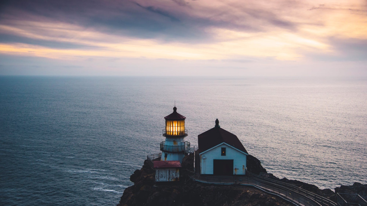 Маяк на скале на фоне горизонта океана 