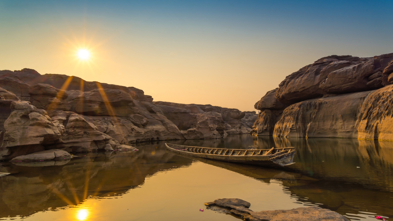 Лодна на озере между скал на рассвете