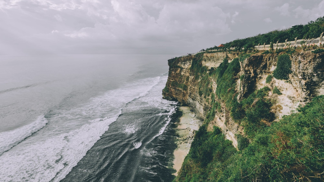 Бушующие волны у зеленого утеса 