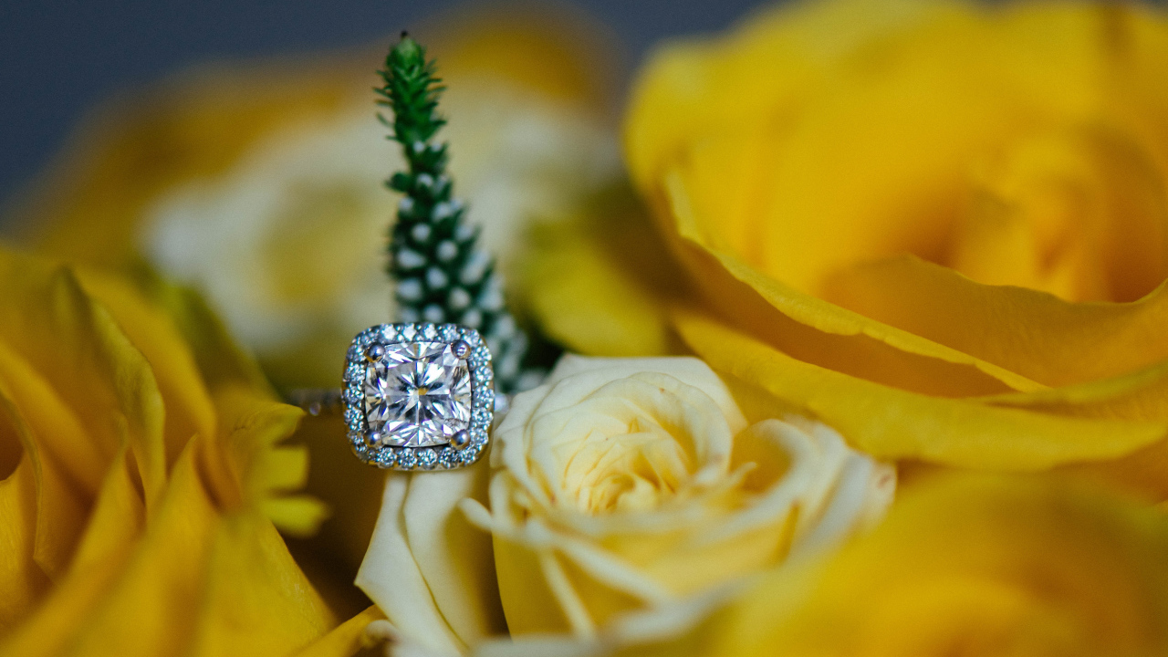 Красивые желтые розы и дорогое кольцо с бриллиантом крупным планом