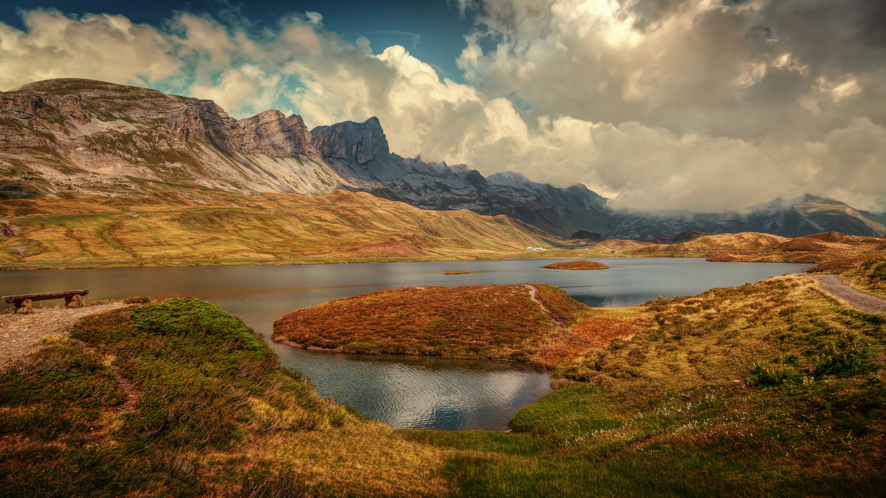 Горы под белыми облаками у озера в Швейцарии