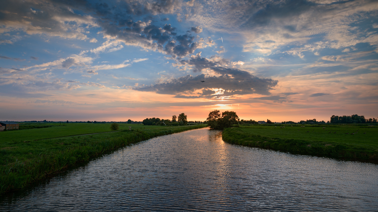 Закат солнца в облаках  над спокойной рекой
