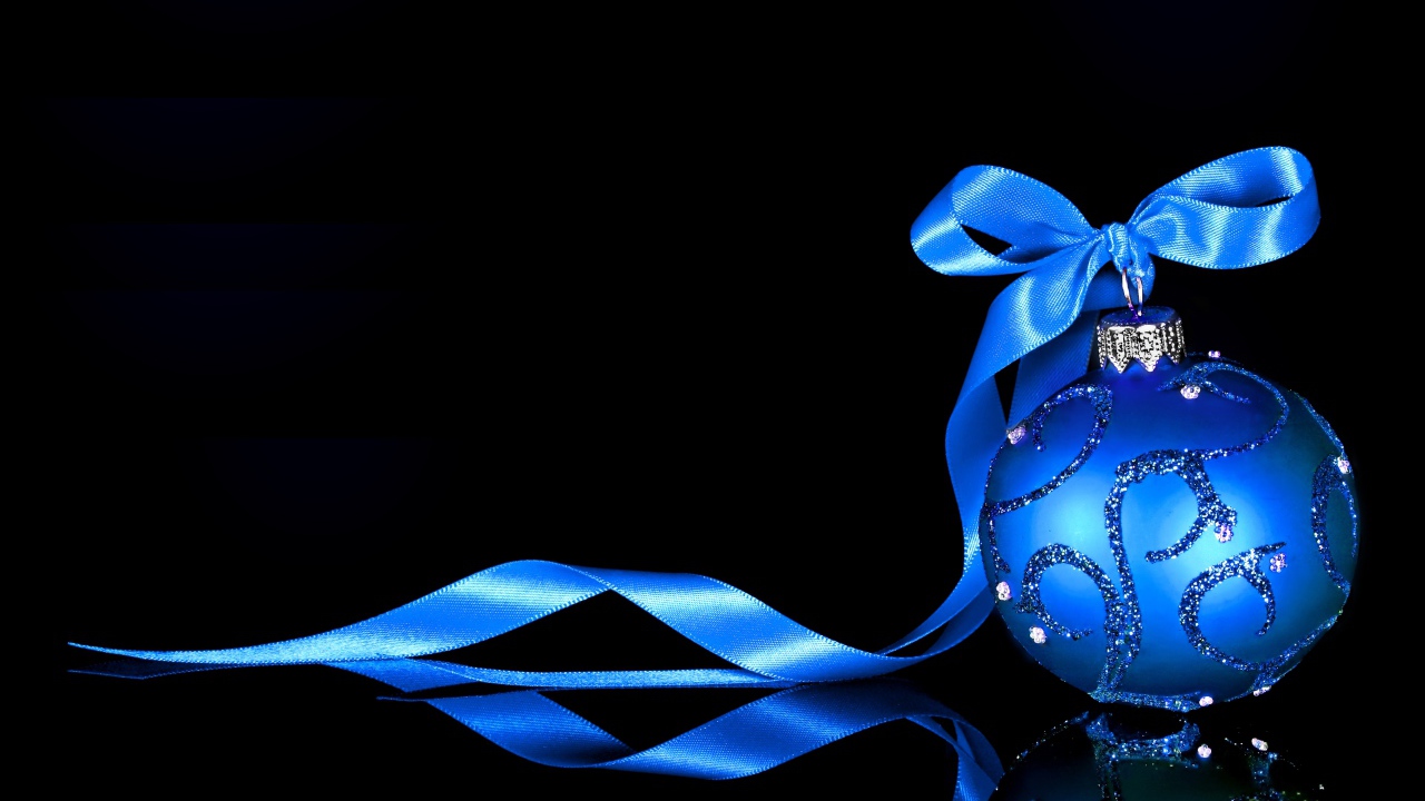 Красивый елочный шар с голубой лентой на черном фоне