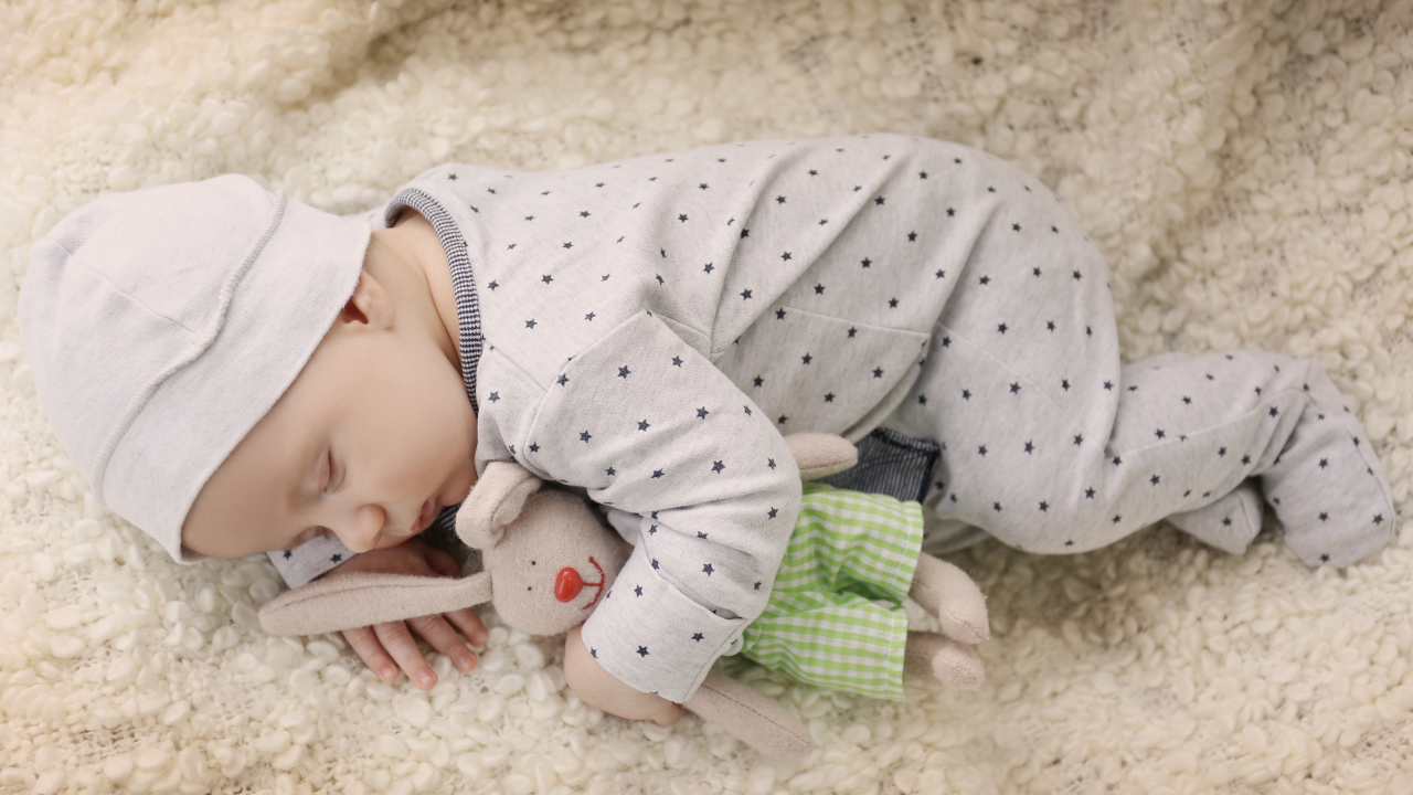 Грудной ребенок спит с любимой мягкой игрушкой