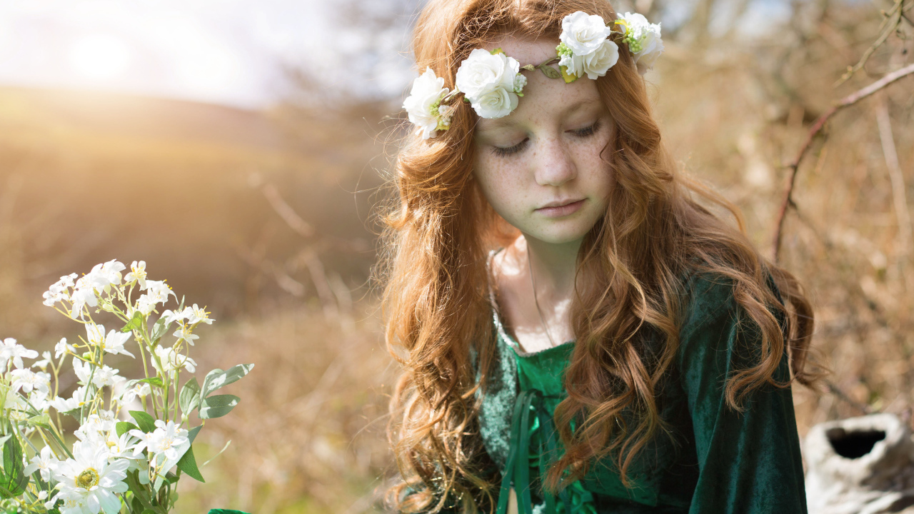 Милая рыжеволосая девочка в зеленом платье с венком на голове