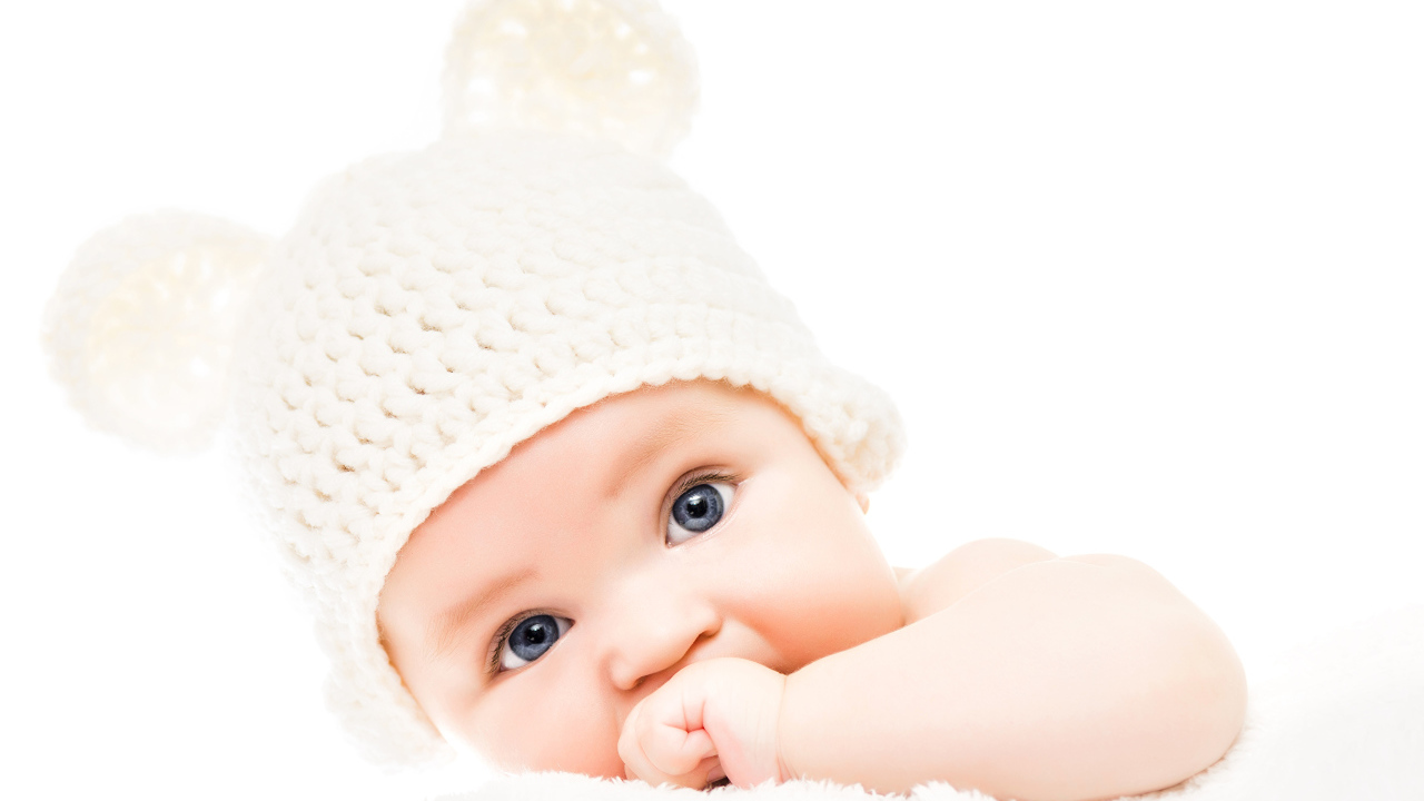 Голубоглазый младенец с белой шапке с ушками на белом фоне