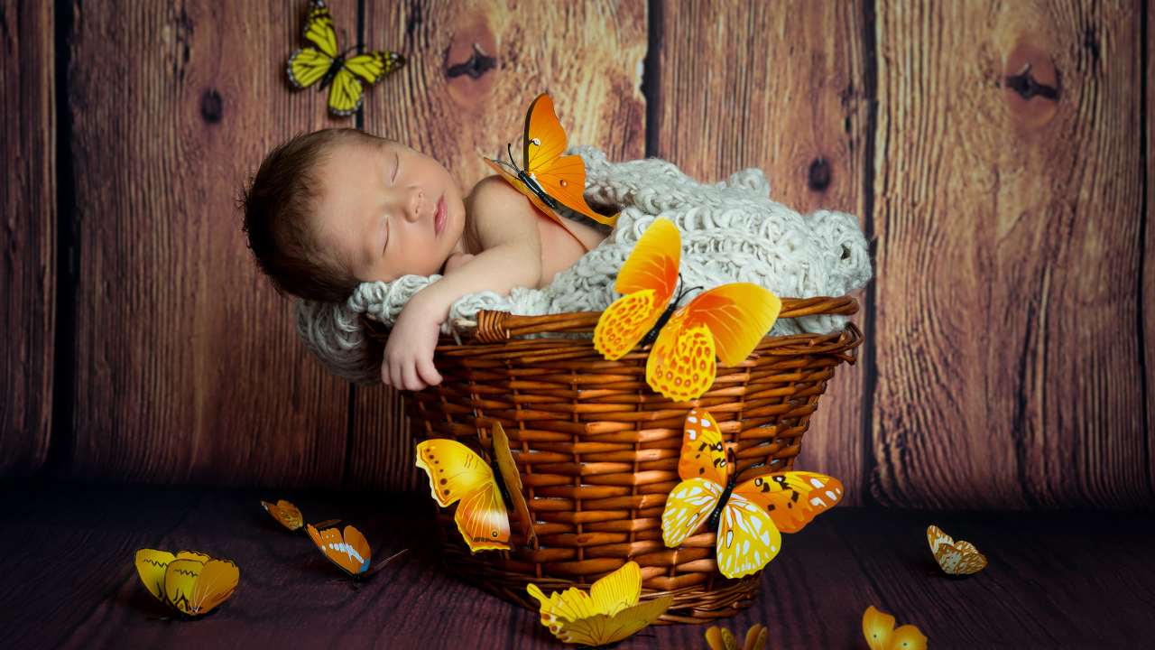 Милый спящий младенец в корзине с бабочками