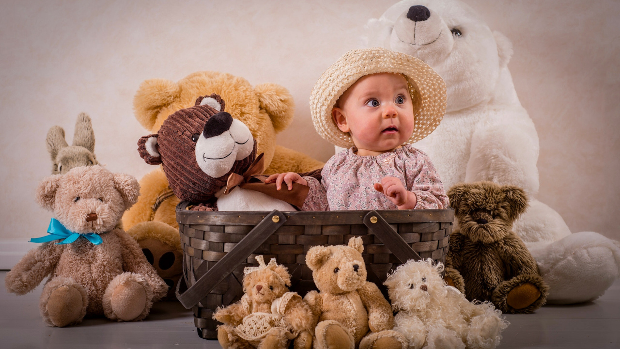 Забавный грудной ребенок в корзине с мягкими игрушками