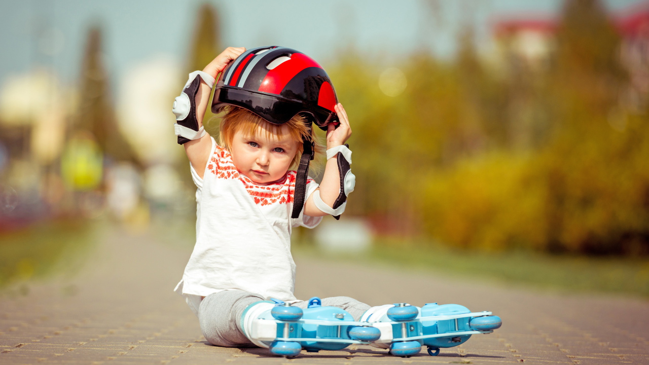 Маленький мальчик в шлеме и роликовых коньках