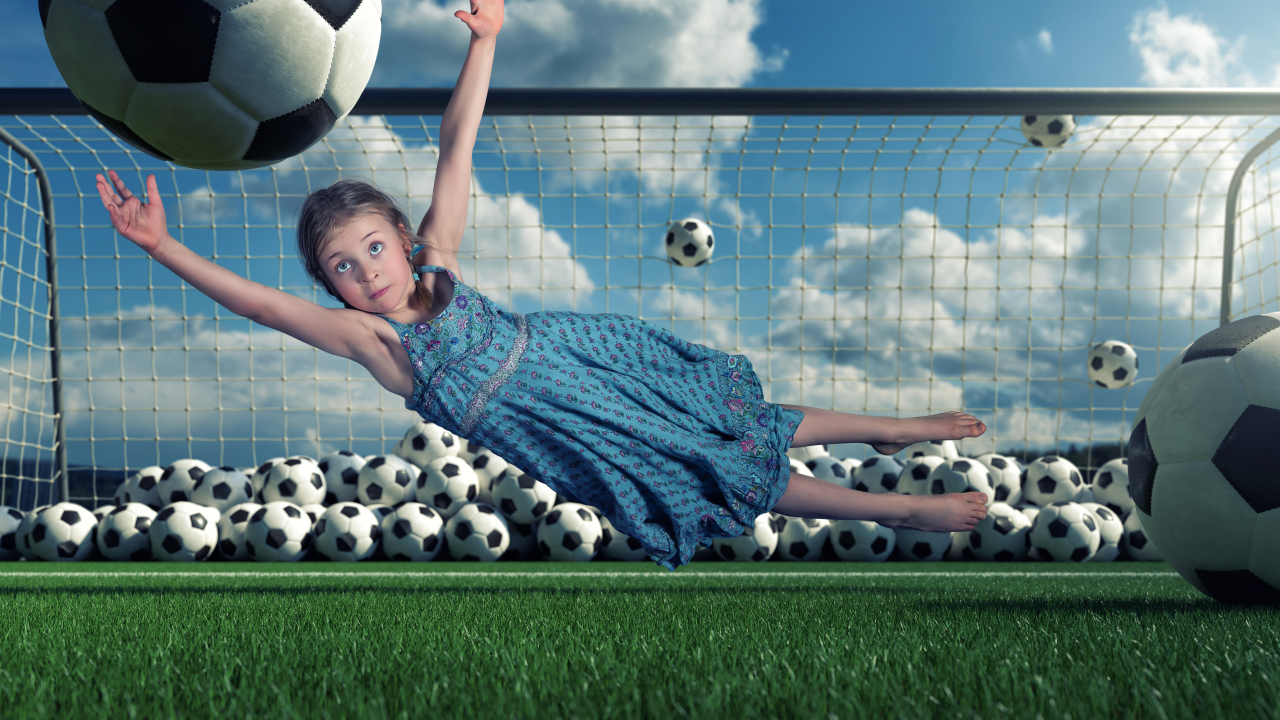 Маленькая девочка вратарь ловит мяч в воротах