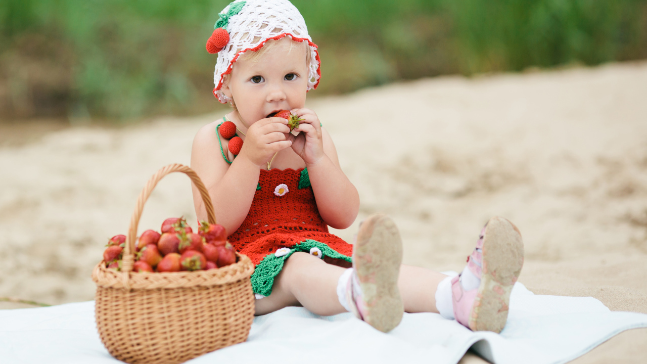 Маленькая девочка в большой корзиной клубники